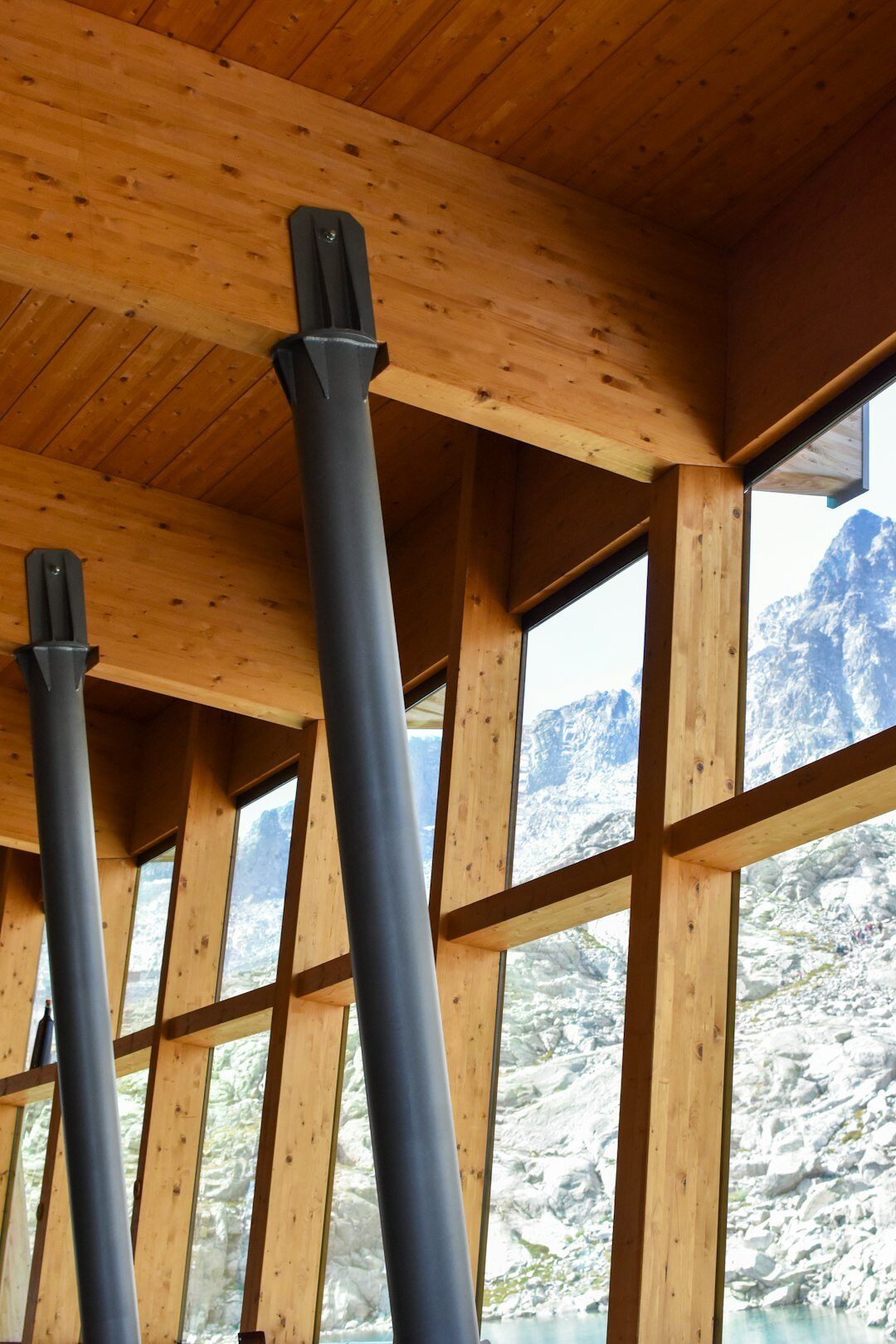 Swiss alpine chalet interior with wood beams, stone fireplace and large windows